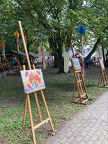 Sztalugi z obrazami, rozstawione w ogrodzie