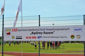 Baner, rozwieszony na płocie, promujący wydarzenie
