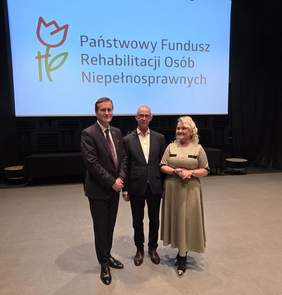 Pokaż zdjęcie: Na tle logo PFRON stoi Wicewojewoda Lubuski Tomasz Nesterowicz, Dyrektor Oddziału Lubuskiego PFRON Elżbieta Miernik-Krukurka oraz prowadzący spotkanie Wojciech Brodziński