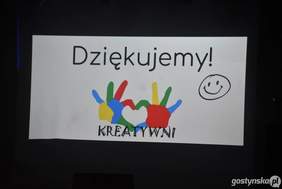 Pokaż zdjęcie: Biały prostokątny plakat na czarnym tle. Na środku znajduje się duży napis "Dziękujemy!" czarną czcionką. Pod napisem są narysowane kolorowe dłonie ustawione pionowo w różnych kolorach: żółtym, niebieskim, zielonym, czerwonym. Pod dłońmi napis "KREATYWNI". Po prawej stronie znajduje się prosty rysunek uśmiechniętej buźki