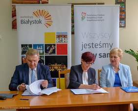 Prezydent Miasta Białegostoku Tadeusz Truskolaski oraz p.o. Dyrektora Oddziału Podlaskiego PFRON Grażyna Bogdańska w takcie podpisywania umów. Z prawej strony: Dyrektor Centrum Kształcenia Ustawicznego w Białymstoku - Bożena Krasnodębska.
