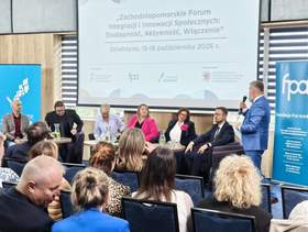 Panel dyskusyjny podczas Zachodniopomorskiego Forum Integracji i Innowacji Społecznych „Dostępność, Aktywność, Włączenie”, które odbyło się 15–16 października 2026 r. w Dźwirzynie. Paneliści siedzą na scenie, a prowadzący z mikrofonem zwraca się do uczestników zgromadzonych na sali. W tle widoczne są ekran z nazwą wydarzenia i banery organizatorów.