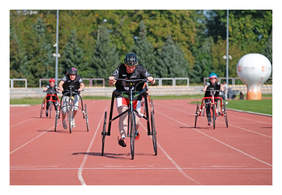 Na bieżni na stadionie czterej zawodnicy frame running w sportowych strojach, biegną