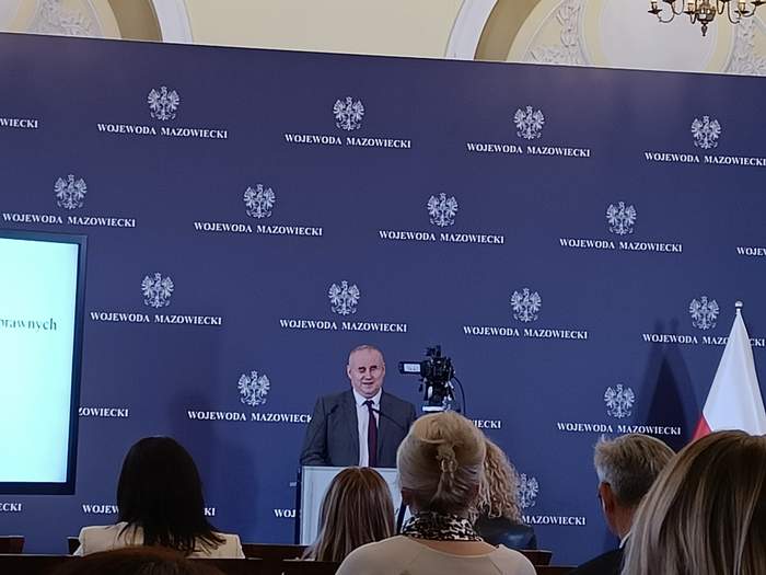 Pokaż zdjęcie: Na scenie, za mównicą przemawia  Pełnomocnik Rządu do Spraw Osób Niepełnosprawnych, Sekretarz Stanu w Ministerstwie Rodziny i Polityki Społecznej Paweł Wdówik.