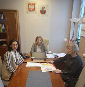 Pokaż zdjęcie: Przy stole konferencyjnym siedzą trzy osoby. Od lewej: Dyrektor Powiatowego Centrum Pomocy Rodzinie Sylwia Domżała-Kurtiak, Starosta Powiatu Węgrowskiego Ewa Besztak, Lilianna Kałczyńska - Samodzielny Specjalista ds. współpracy z administracją publiczną w Mazowieckim Oddziale PFRON.