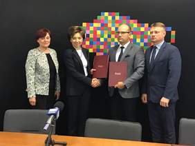 Pokaż zdjęcie: Fotografia zbiorowa, Marlena Maląg i Artur Kosicki w geście uścisku rąk. 