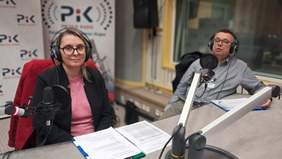 Kobieta i mężczyzna, siedzą, w słuchawkach na uszach, przed nimi mikrofon radiowy