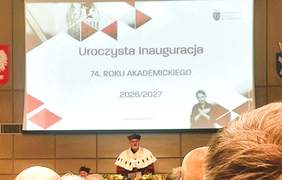 Pokaż zdjęcie: Na środku Auli Rektor prowadzący Inauguracje, za nim ekran z napisem Inauguracja Roku Akademickiego.