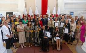 Pokaż zdjęcie: Zdjęcie pamiątkowe  grupa osób pozuje do zdjęcia, część osób trzyma nagrody w ręku