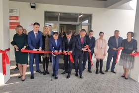 Pokaż zdjęcie: Kobiety oraz mężczyźni przecinają czerwoną wstęgę