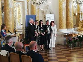 Pokaż zdjęcie: Finaliści konkursu – dwóch panów i trzy panie, ubranych na czarno-biało w towarzystwie piosenkarki jazzowej w białym kostiumie.