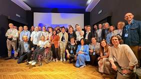 Pokaż zdjęcie: Zdjęcie grupowe w sali kinowej. Na zdjęciu są organizatorzy, jurorzy, nagrodzeni i goście. 