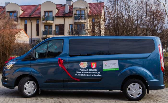 Pokaż zdjęcie: 9-osobowy mikrobus Ford Transit Custom MCA - samochód dofinansowany ze środków PFRON dla uczniów SOSW w Skawinie (Fot. SOSW w Skawinie) Na zdjęciu samochód symbolicznie przewiązany czerwoną wstęgą