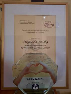 Pokaż zdjęcie: Przed dyplomem stoi statuetka. Są to wyróżnienia przyznane dyrektorowi Łódzkiego Oddziału PFRON. 
