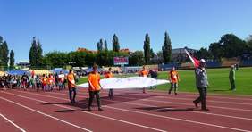 Zawodnicy niosą flage olimpijską, a za nimi idą pozostali uczestnicy zawodów