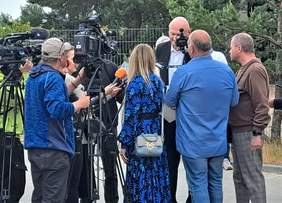 Prezydent Torunia Michał Zaleski podczas udzielania wywiadu, zasłonięty przez grupę reporterów