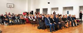 Pokaż zdjęcie: Sala konferencyjna, na krzesełkach ustawionych w rzędach siedzą zaproszeni goście