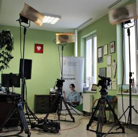 Pokaż zdjęcie: Trzy kamery telewizje, w tle baner PFRON