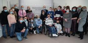 Zdjęcie grupowe około 30 osób. Są na nim mężczyźni i kobiety, pracownicy jak i podopieczni PSONI Koło w Jarosławiu
