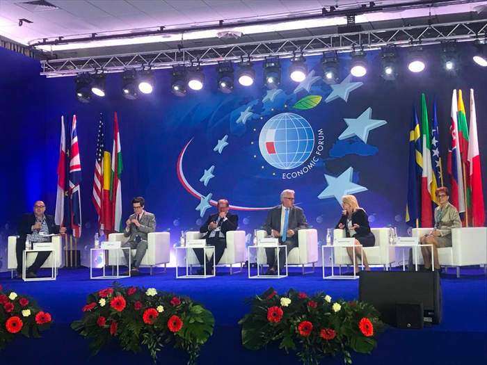 Pokaż zdjęcie: Scena, na niej na krzesłach siedzą paneliści