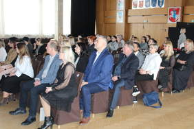 Pokaż zdjęcie: Zdjęcie uczestników konferencji siedzących na krzesłach ustawionych w rzędach.