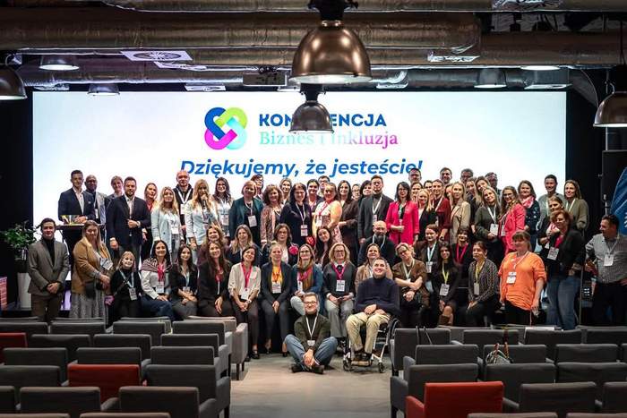 Wspólne zdjęcie uczestników konferencji „Biznes i Inkluzja” na tle ekranu z napisem „Dziękujemy, że jesteście”. Na scenie zgromadzili się organizatorzy, prelegenci i uczestnicy wydarzenia poświęconego współpracy biznesu i integracji społecznej.