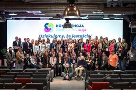 Wspólne zdjęcie uczestników konferencji „Biznes i Inkluzja” na tle ekranu z napisem „Dziękujemy, że jesteście”. Na scenie zgromadzili się organizatorzy, prelegenci i uczestnicy wydarzenia poświęconego współpracy biznesu i integracji społecznej.