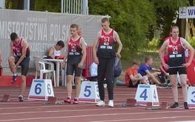 Pokaż zdjęcie: czterej mężczyźni stoją na bieżni ubrani są w stroje sportowe, przygotowują się do biegu.