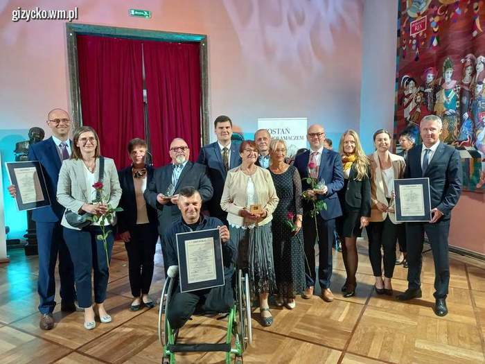 Pokaż zdjęcie: Przedstawiciele wyróżnionych firm i instytucji pozują do zdjęcia. Po środku stoi dyrektor Oddziału PFRON Mateusz Szkaradziński