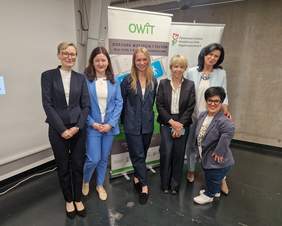 Pokaż zdjęcie: Sześć uśmiechniętych kobiet pozuje do zdjęcia na tle logo OWiT i PFRON