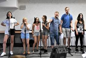 Pokaż zdjęcie: Grupa siedmiorga artystów podczas warsztatów muzycznych, przygotowujących do występów podczas koncertów
