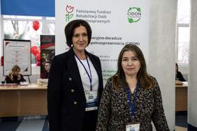 Pokaż zdjęcie: Na tle rollupu z logo CIDON pozują dwie kobiety.