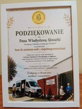 Pokaż zdjęcie: W białej ramce znajduje się dyplom z podziękowaniami dla dyrektora Łódzkiego Oddziału PFRON Władysława Skwarki. 