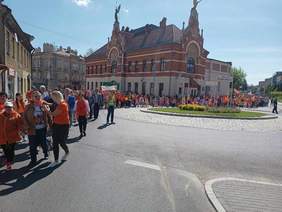 Przemarsz uczestników marszu ulicami Jarosławia, jasny dzień, tłum ludzi maszerujący na tle budynków miasta