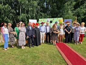 kilkanaście osób w szeregu w wesołych kapeluszach, stoją, uśmiechają się