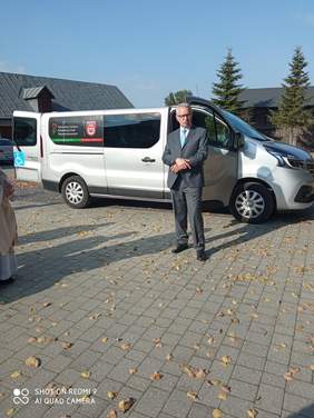 Pokaż zdjęcie: wystąpienie prezesa PFRON w tle zakupiony bus w kolorze srebrnym