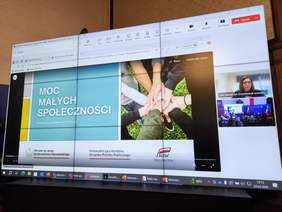 Pokaż zdjęcie: Zdjęcie ekranu z białym napisem „Moc Małych Społeczności” w Szczecinie