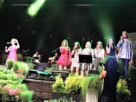 Pokaż zdjęcie: Wokalistka i chórek występują na scenie podczas Festiwalu