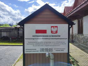 Pokaż zdjęcie: Tablica z informacją o dofinansowaniu budynku z funduszu PFRON.