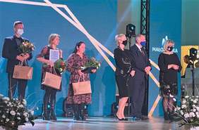 Pokaż zdjęcie: Scena Filharmonii. Na scenie stoi kilka elegancko ubranych osób - laureaci oraz wręczający nagrody