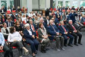 Grupa osób, kobiety i mężczyźni, siedzą