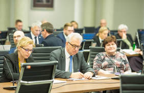 Pokaż zdjęcie: Prezes PFRON siedzi przy stole konferencyjnym 