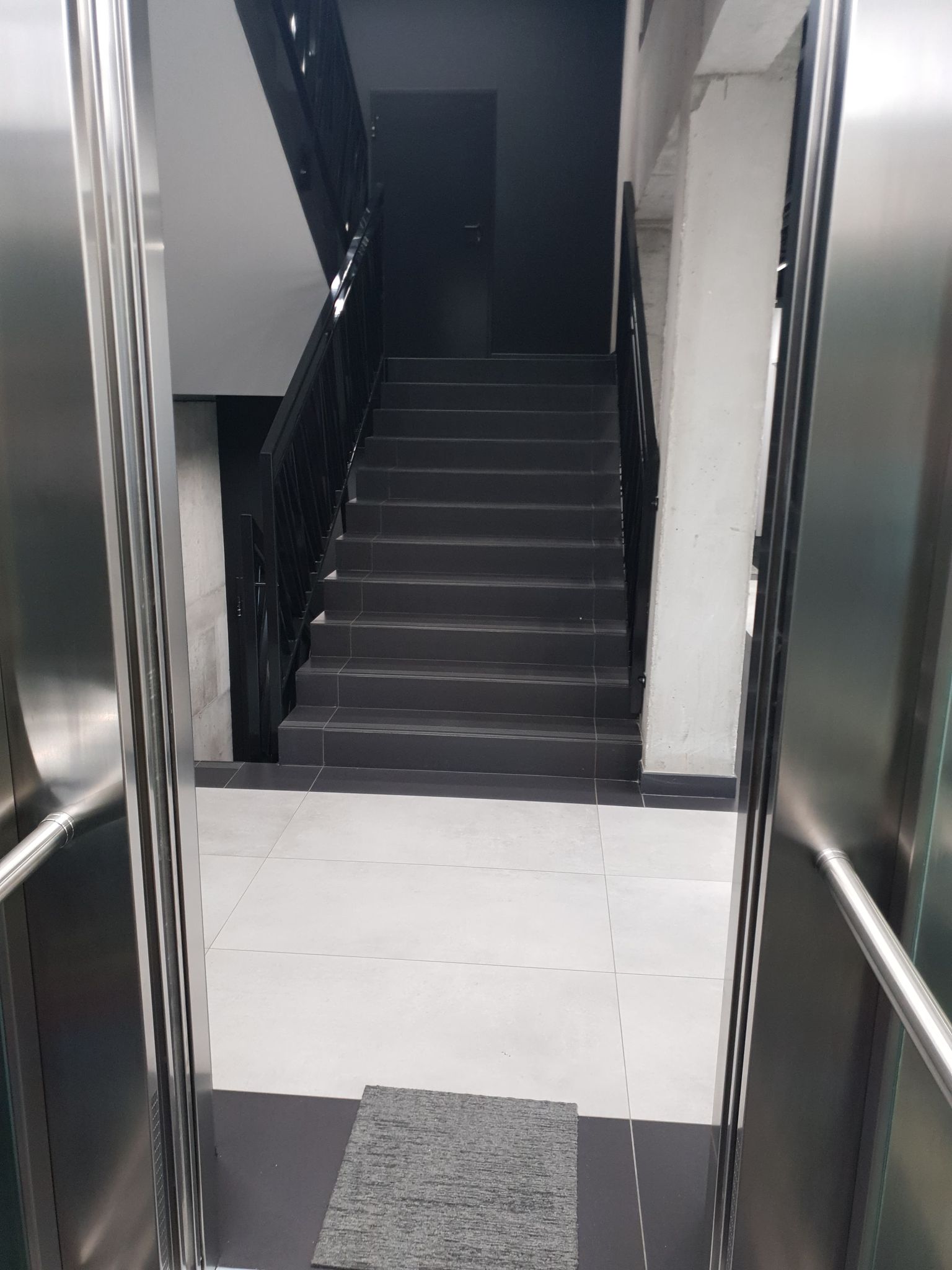 Widok z windy na schody Widok z wnętrza windy na klatkę schodową.